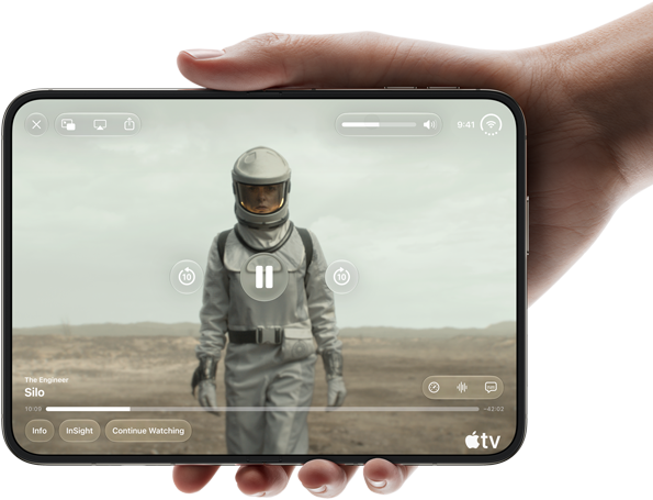 En hånd holder iPhone Duo åpen i liggende format og brettet helt ut. På skjermen vises Apple TV-serien Silo