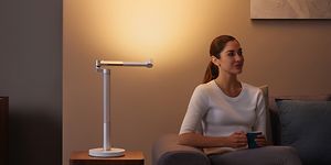 Dyson Lightcycle bordlampe som lyser opp en vegg