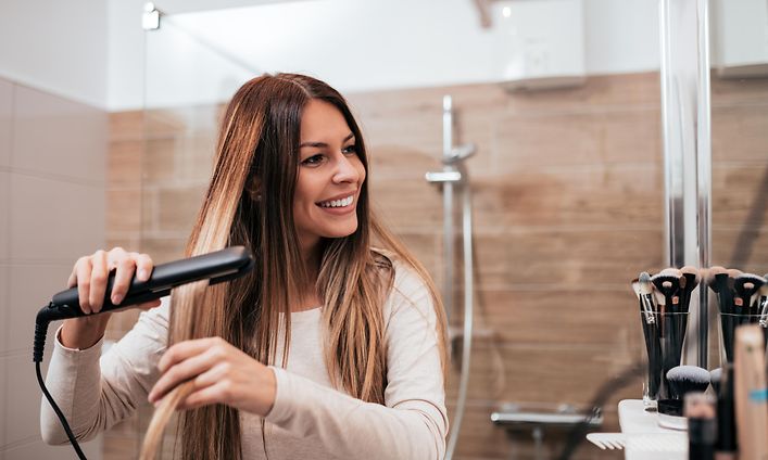 Woman using hair straightener